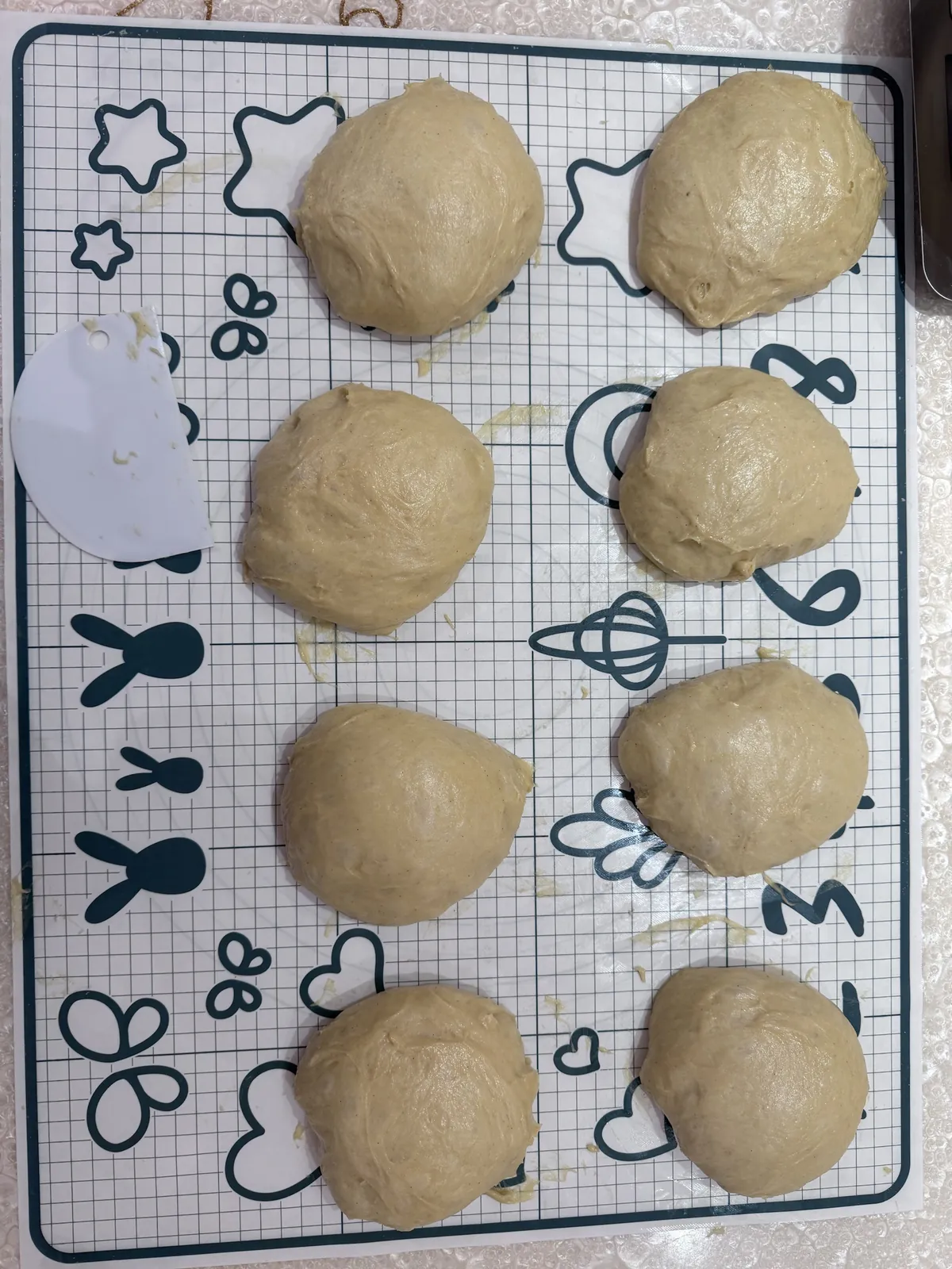 Eight portioned dough balls on a silicone mat